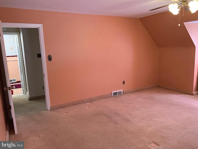 additional living space with light carpet, ceiling fan, vaulted ceiling, and baseboards