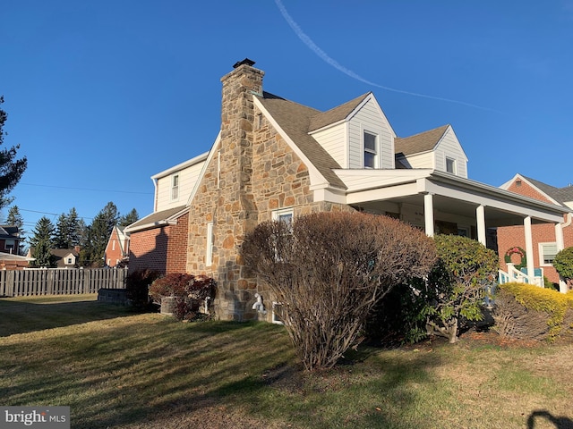 view of side of property featuring a chimney and stone siding