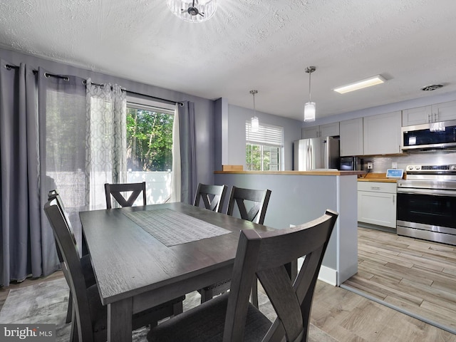 331 Possum Ct, Capitol Heights, MD 20743 - dining area featuring light wood-style floors, a textured ceiling, and visible vents