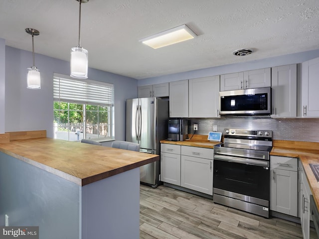 331 Possum Ct, Capitol Heights, MD 20743 - kitchen featuring light wood finished floors, wooden counters, stainless steel appliances, backsplash, and pendant lighting