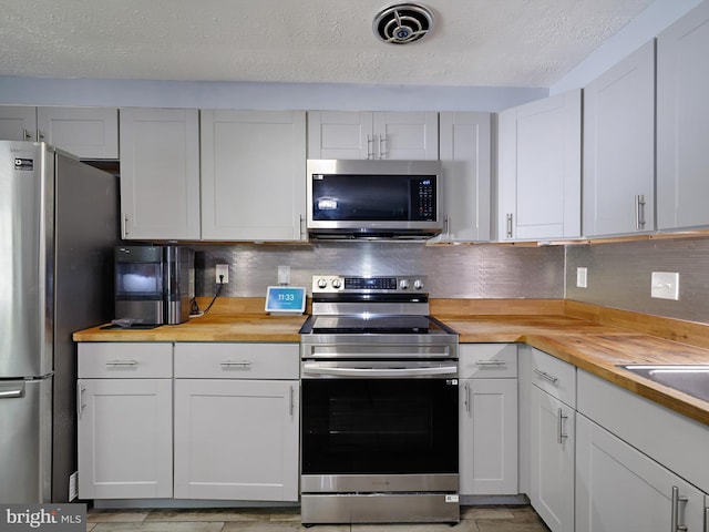 331 Possum Ct, Capitol Heights, MD 20743 - kitchen featuring backsplash, stainless steel appliances, and butcher block counters