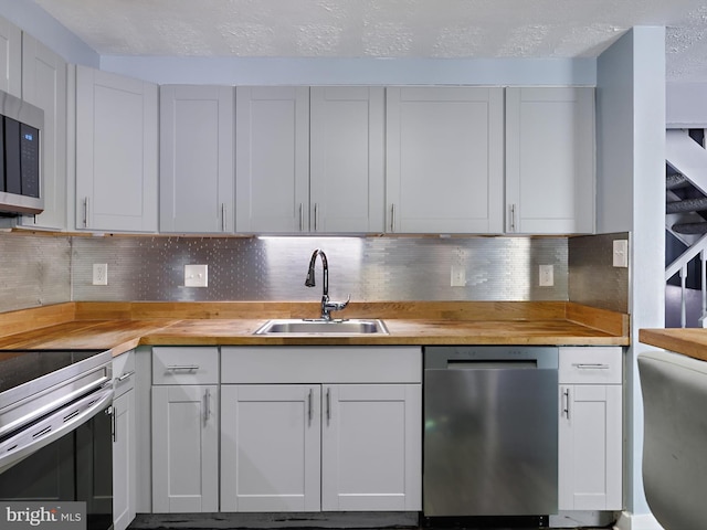 331 Possum Ct, Capitol Heights, MD 20743 - kitchen featuring a sink, appliances with stainless steel finishes, backsplash, and wooden counters
