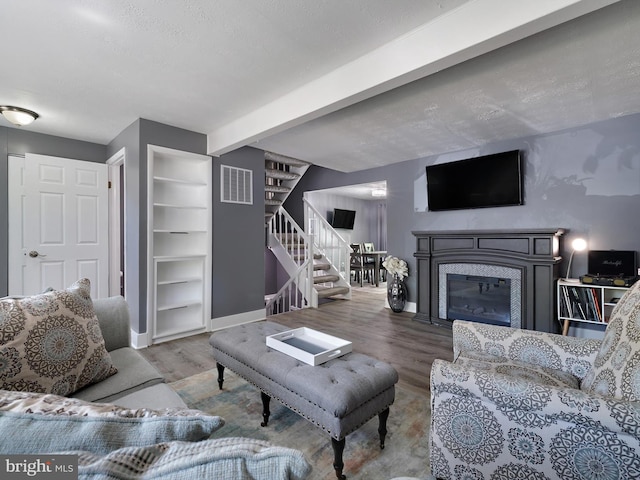 331 Possum Ct, Capitol Heights, MD 20743 - living area featuring baseboards, a glass covered fireplace, wood finished floors, and stairway
