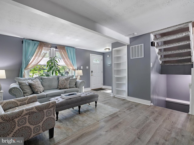 331 Possum Ct, Capitol Heights, MD 20743 - living area with a textured ceiling, baseboards, wood finished floors, beamed ceiling, and visible vents