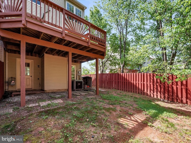 view of yard featuring fence, cooling unit, and a deck