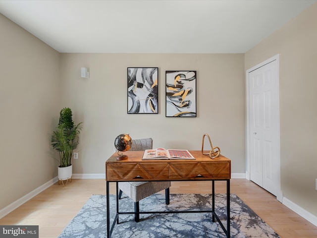 office area with baseboards and light wood-style flooring