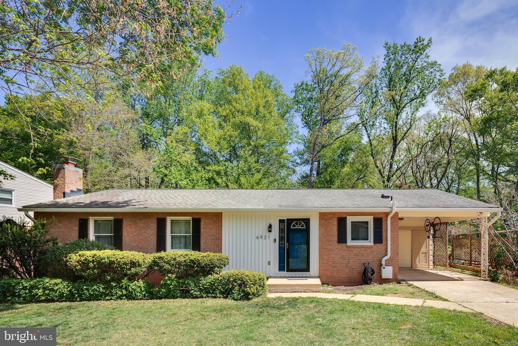 single story home with brick siding, driveway, a front yard, and an attached carport
