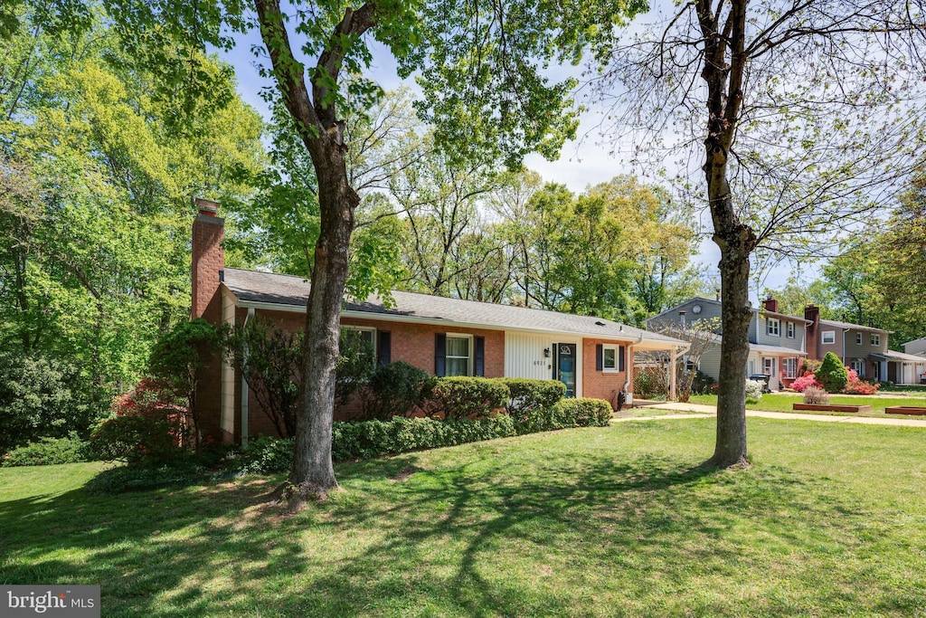 view of front of property with a chimney, brick siding, and a front yard