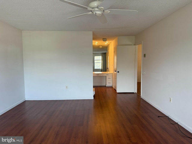 492 Delair Rd Unit C, Monroe, NJ 08831 - empty room with a textured ceiling, baseboards, built in desk, ceiling fan, and dark wood-type flooring