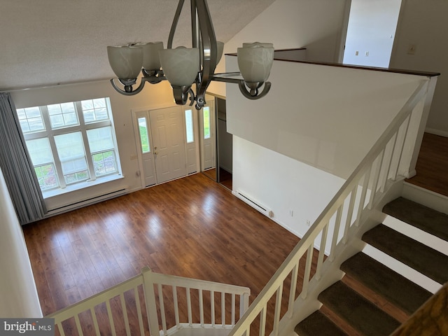 492 Delair Rd Unit C, Monroe, NJ 08831 - foyer entrance featuring a baseboard heating unit, vaulted ceiling, wood finished floors, and an inviting chandelier