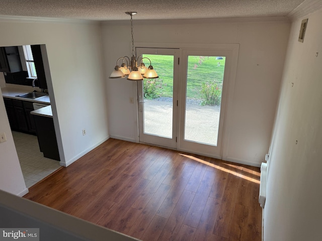 492 Delair Rd Unit C, Monroe, NJ 08831 - unfurnished dining area featuring crown molding, a sink, a textured ceiling, an inviting chandelier, and light wood-style flooring