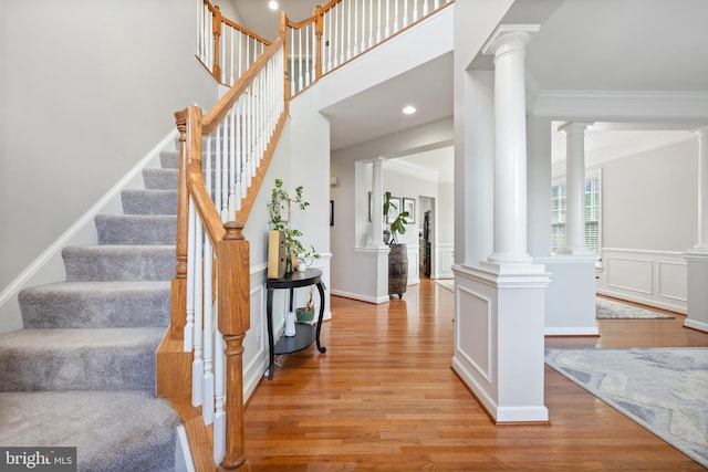 14401 Broadwinged Dr, Gainesville, VA 20155 - foyer entrance with wood finished floors, decorative columns, crown molding, and stairway