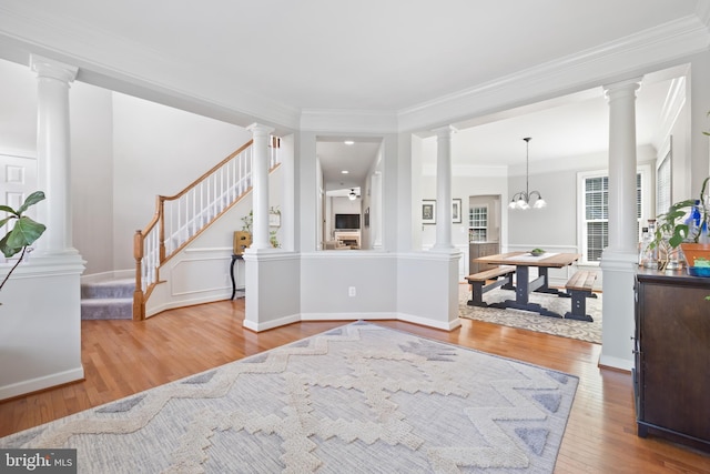 14401 Broadwinged Dr, Gainesville, VA 20155 - entrance foyer featuring crown molding, wood finished floors, stairway, ornate columns, and a chandelier