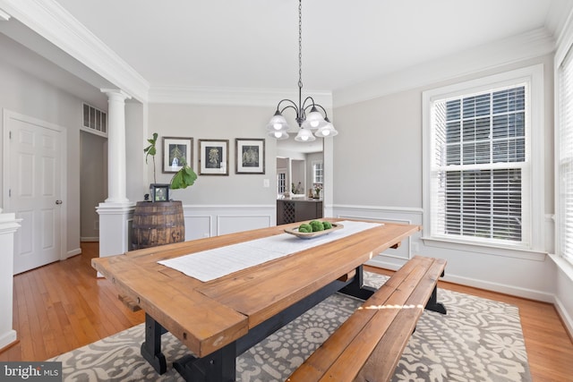 14401 Broadwinged Dr, Gainesville, VA 20155 - dining room featuring ornate columns, light wood-style flooring, ornamental molding, a chandelier, and a wainscoted wall