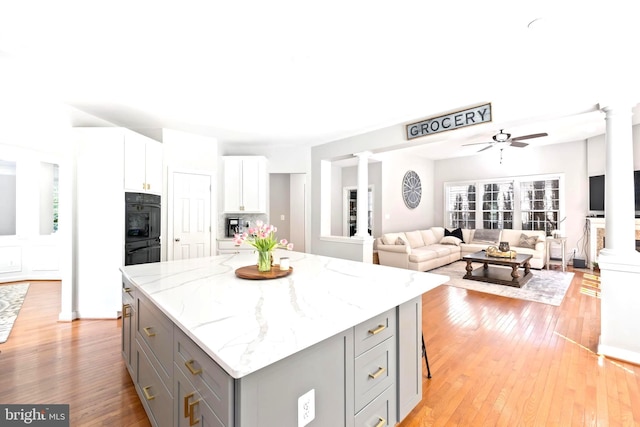 14401 Broadwinged Dr, Gainesville, VA 20155 - kitchen featuring decorative columns, gray cabinets, light wood-style floors, and a kitchen island