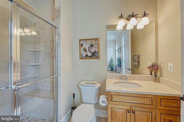bathroom with toilet, baseboards, vanity, and a stall shower