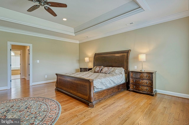 bedroom with a ceiling fan, wood finished floors, a raised ceiling, baseboards, and ornamental molding