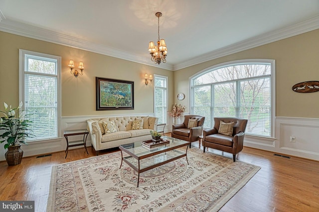 living area with visible vents, ornamental molding, and a healthy amount of sunlight