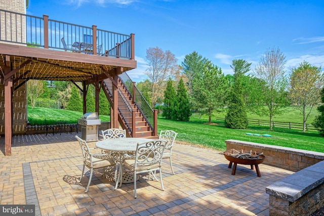view of patio featuring stairway, area for grilling, fence, a wooden deck, and outdoor dining area
