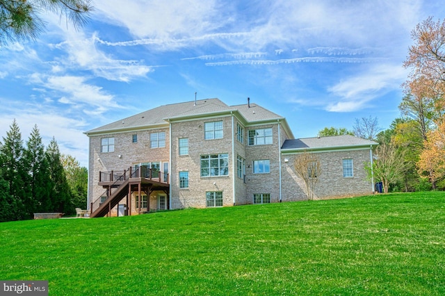rear view of house with a yard, a deck, and stairs