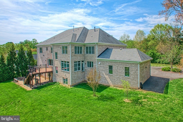 rear view of house featuring a patio area, a deck, and a lawn