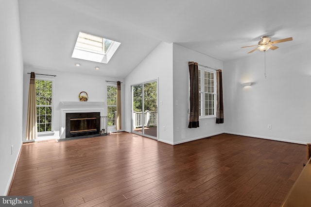 46878 Graham Cv, Sterling, VA 20165 - unfurnished living room with wood finished floors, a ceiling fan, lofted ceiling with skylight, baseboards, and a glass covered fireplace