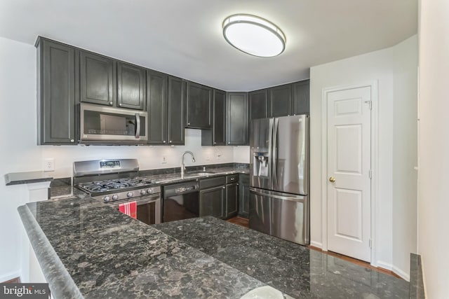 46878 Graham Cv, Sterling, VA 20165 - kitchen featuring a sink, baseboards, dark stone counters, and appliances with stainless steel finishes
