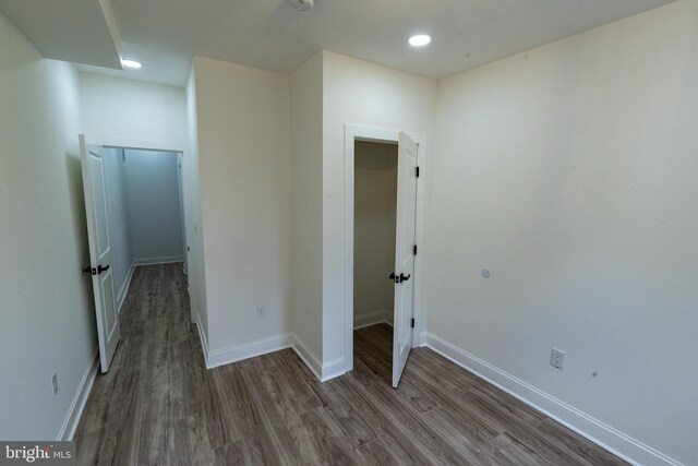 unfurnished bedroom featuring wood finished floors, baseboards, and recessed lighting