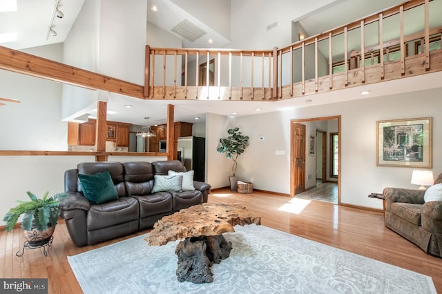 16 Hunters Ln, Chadds Ford, PA 19317 - living room featuring baseboards, rail lighting, light wood-style flooring, and high vaulted ceiling