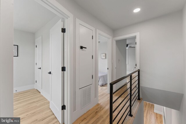 hall with recessed lighting, baseboards, an upstairs landing, light wood-type flooring, and visible vents