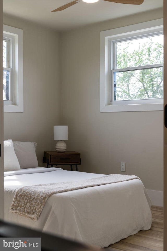 bedroom featuring baseboards and wood finished floors