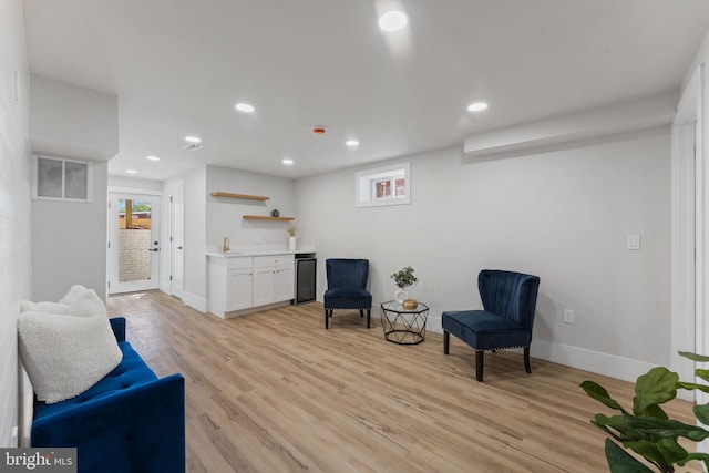 living area featuring wet bar, visible vents, light wood finished floors, recessed lighting, and a wealth of natural light