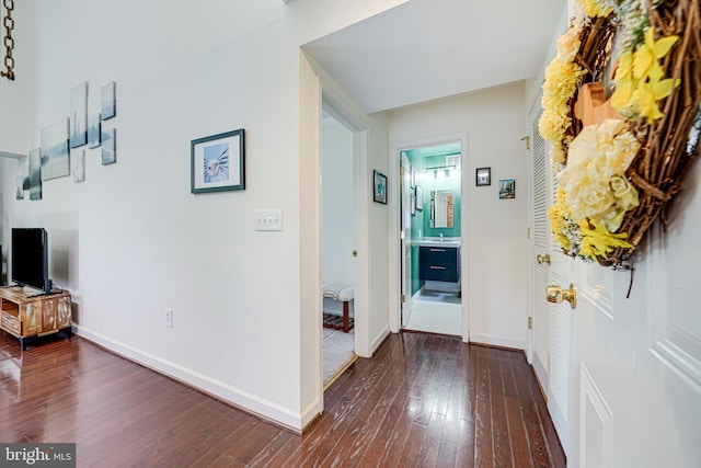 corridor with dark wood-style floors and baseboards