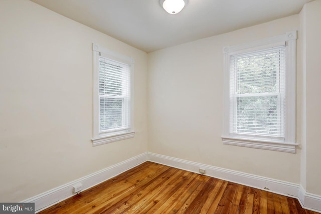 empty room featuring baseboards and wood finished floors