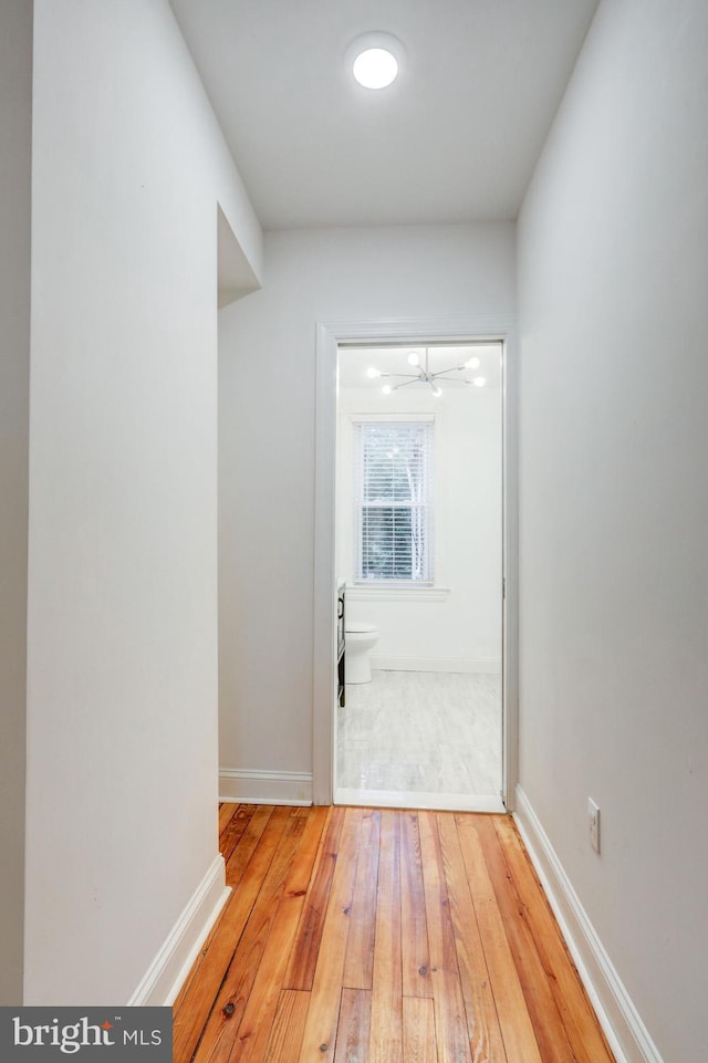 corridor with hardwood / wood-style flooring and baseboards