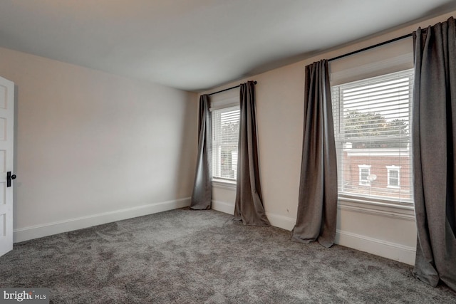 carpeted spare room featuring baseboards