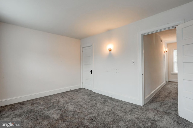 unfurnished room featuring baseboards and carpet