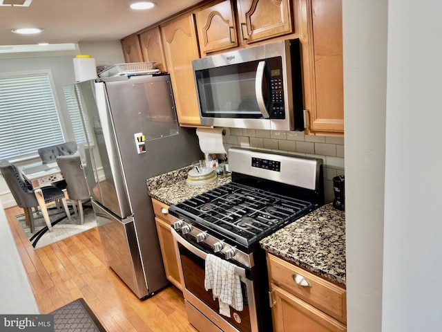 218 Stevenson Sq, Alexandria, VA 22304 - kitchen with stainless steel appliances, light wood-type flooring, dark stone countertops, and decorative backsplash