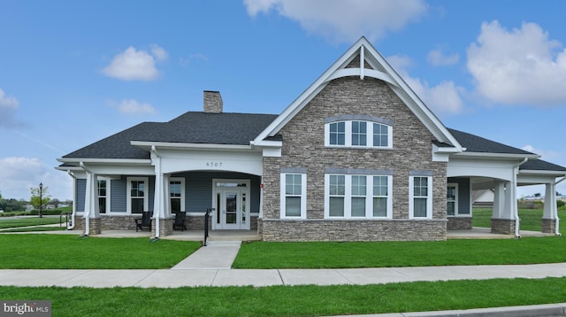 5214 Red Maple Dr, Frederick, MD 21703 - craftsman house featuring a front yard, stone siding, covered porch, and a chimney