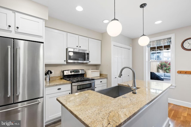kitchen featuring a sink, stainless steel appliances, light wood-type flooring, and white cabinetry