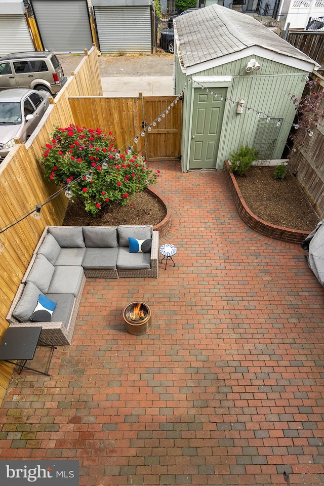 view of patio / terrace featuring a gate, an outbuilding, a shed, and a fenced backyard