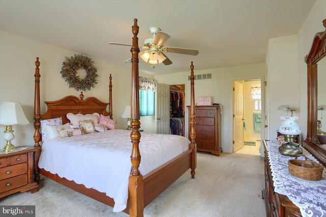 bedroom with ensuite bathroom, visible vents, a spacious closet, light colored carpet, and a closet