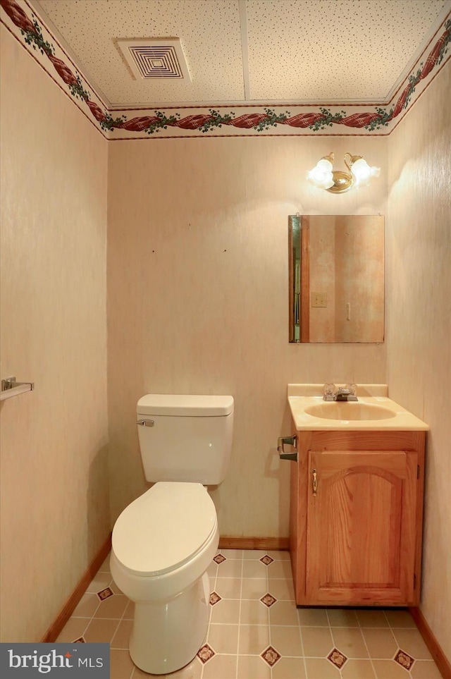 bathroom featuring tile patterned floors, visible vents, toilet, vanity, and baseboards