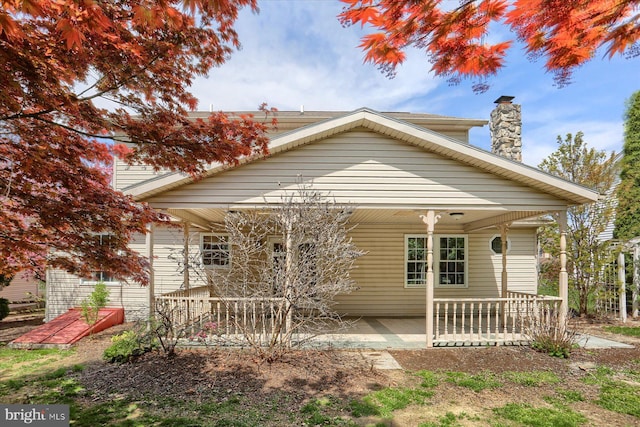 bungalow-style home featuring a chimney and a patio