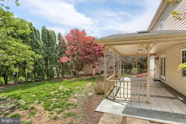 view of yard with a porch and ceiling fan