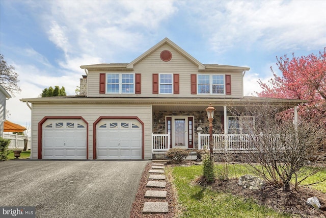view of front of house featuring an attached garage, driveway, and a porch