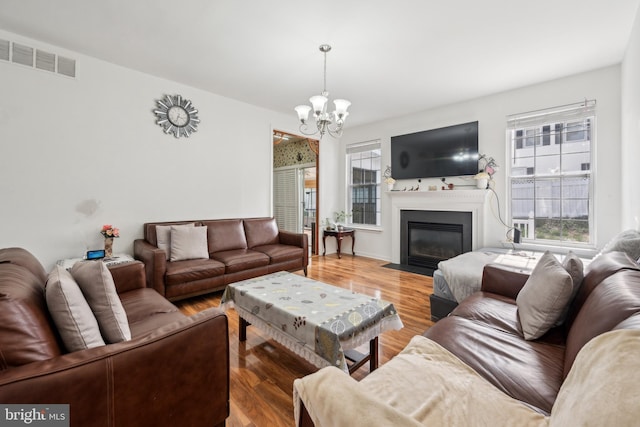 2 Underwood Ct, Burlington, NJ 08016 - living area with visible vents, an inviting chandelier, a fireplace with flush hearth, and light wood-style flooring