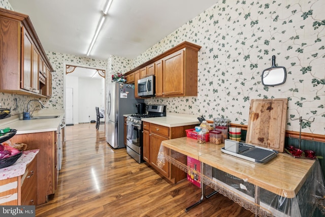 2 Underwood Ct, Burlington, NJ 08016 - kitchen featuring brown cabinets, a sink, stainless steel appliances, wallpapered walls, and light wood finished floors