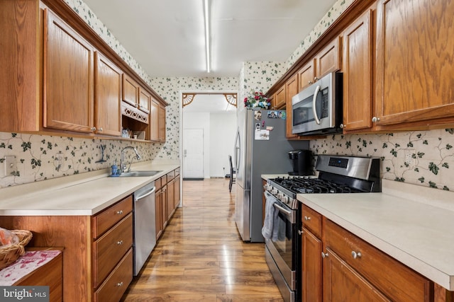 2 Underwood Ct, Burlington, NJ 08016 - kitchen featuring decorative backsplash, a sink, light wood-style floors, stainless steel appliances, and brown cabinetry