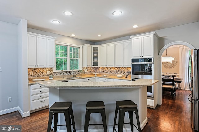 7098 Garden Walk, Columbia, MD 21044 - kitchen with appliances with stainless steel finishes, a breakfast bar, white cabinetry, backsplash, and recessed lighting